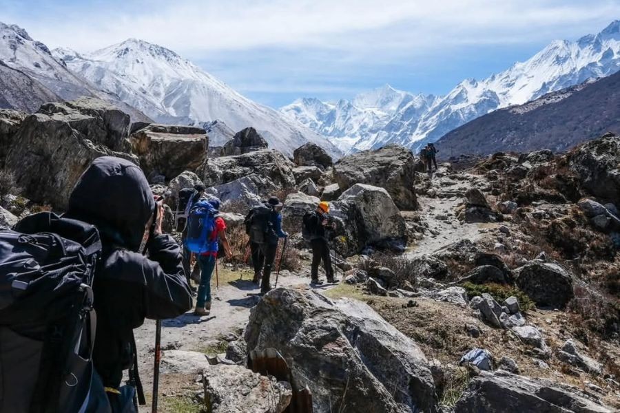 Group of trekkers navigating rocky terrain on Langtang Valley trail